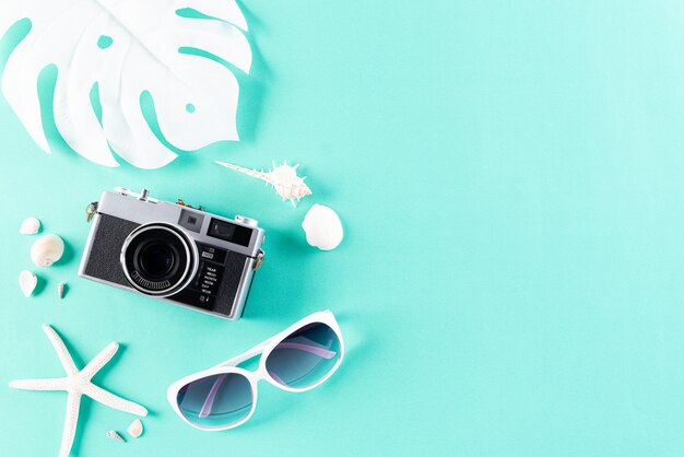 Photo beach accessories on green pastel background for summer holiday concept.