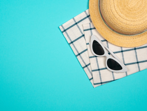 Пляжные аксессуары ретро пленочная камера, солнцезащитные очки, пляжная шляпа морская звезда и морские раковины на синем фоне для летнего отдыха и отпуска