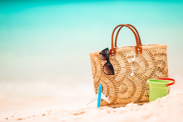 Beach accessories - straw bag, hat and unglasses on the beach