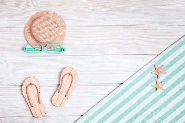 Beach accessories. Summer shoes - flip-flops, cotton towel, hat from sun, sunglasses