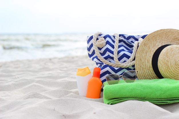 Beach accessories and sunscreens on the sand of the seaside