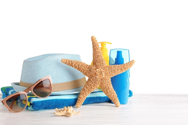 Beach accessories on table against white background Space for text