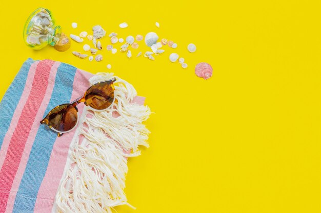 Photo beach accessories with copy space. sunglasses, towel and sea shells