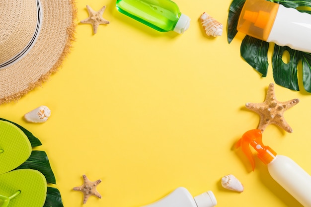 Beach accessories with straw hat, sunscreen bottle and starfish