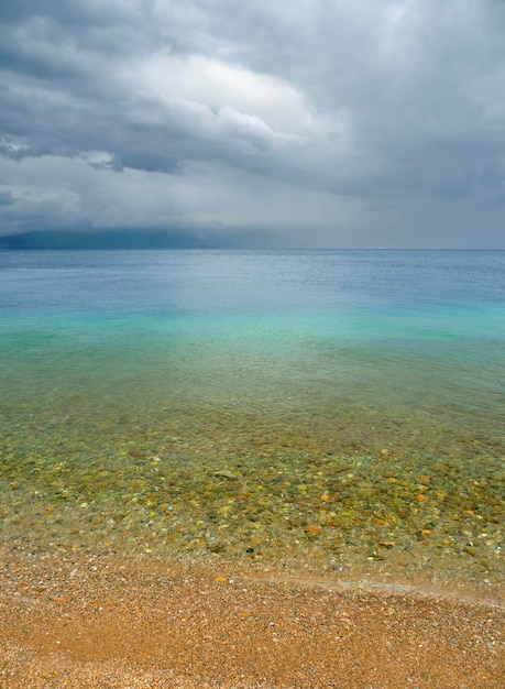 Пляж на Эгейском море в Греции перед дождем и грозой