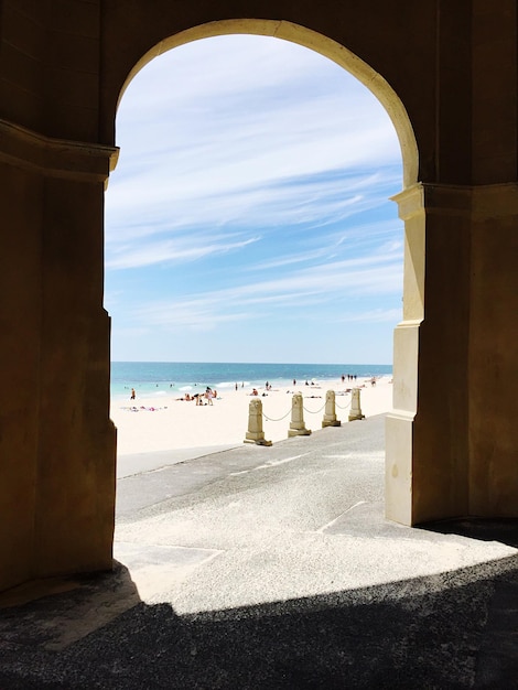 Beach against sky seen through archway