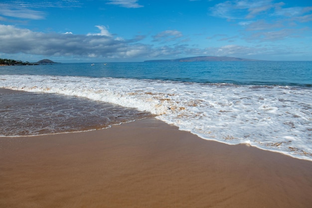 ビーチの背景は熱帯の海のビーチから砂浜の海の景色の美しい海の波を穏やかにします