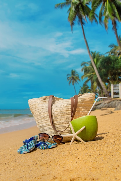 Пляжная сумка и кокос в море.
