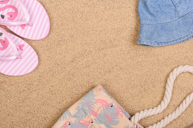 Beach bag, slippers, hat on the sand