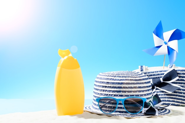 Photo beach bag with leisure accessories and hat on the sandy beach