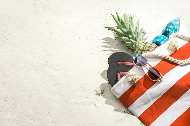 Фото Пляжная сумка с ананасом лежит на белом песке на пляже