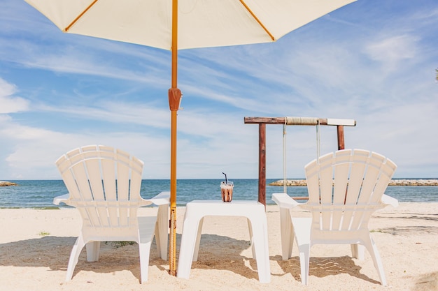 Кафе-бар на пляже в белой теме в ярком небе и синем море тропиков