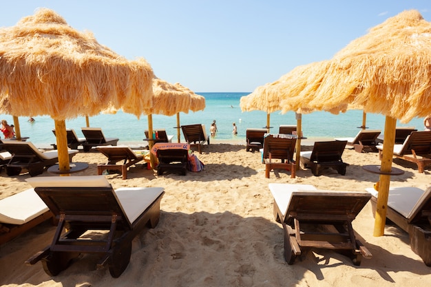 Beach beautiful thatched umbrellas and turquoise sea.