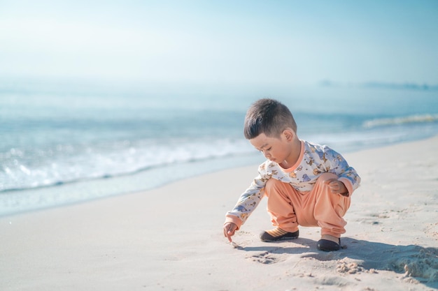 해변에서 한 소년이 모래에서 놀고 있다