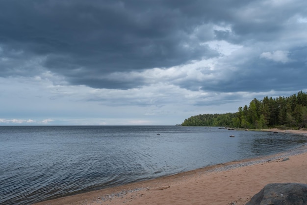 The beach by the lake before a thunderstorm Dark clouds over a calm sea