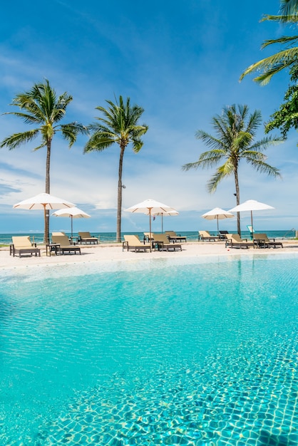 beach chair around swimming pool in hotel resort with sea beach, holiday and vacation concept