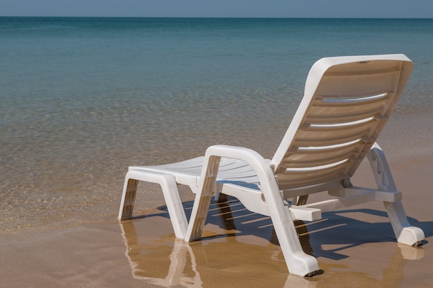 Foto sedia a sdraio sulla costa soleggiata sullo sfondo spiaggia