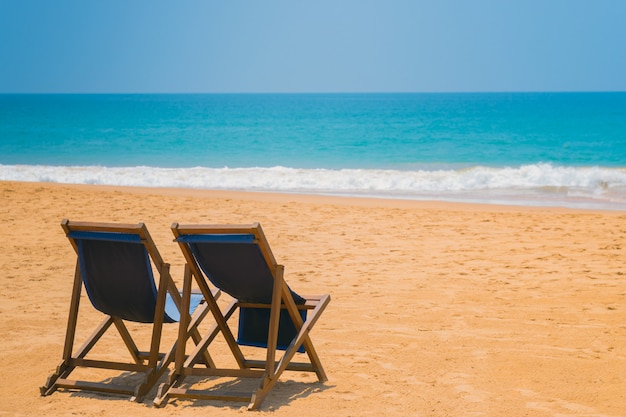 바다의 모래 해변에 비치 의자.