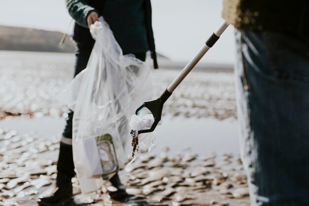 환경 캠페인을 위해 쓰레기를 줍는 해변 청소 자원 봉사자