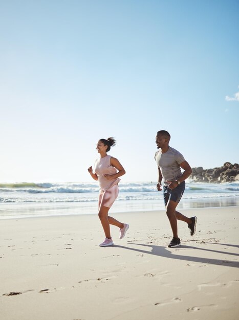 Beach couple running and cardio fitness training or wellness challenge together Friends sports teamwork run and healthy runner lifestyle motivation for energy or exercise workout on ocean sand