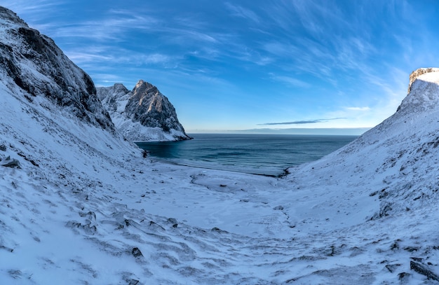 ノルウェー、ロフォーテン諸島の山々に雪に覆われたビーチ