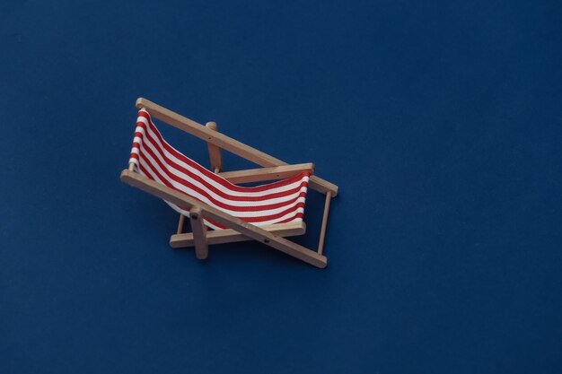 Beach deck chair on classic blue background. Color 2020.