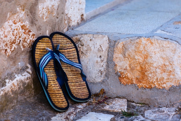 Beach flip-flops on the old wall background. Horizontal shot