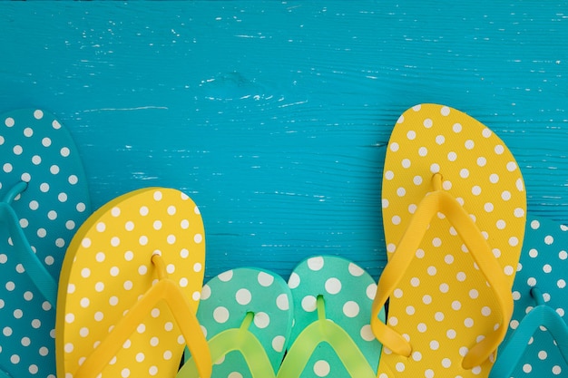 Beach flipflops on blue wooden background