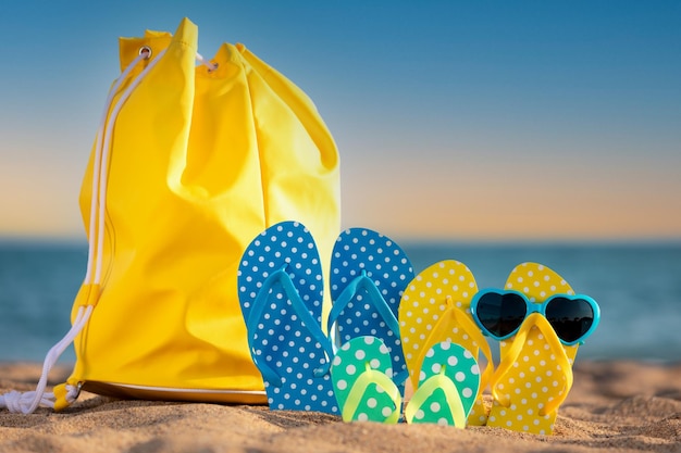 Beach flipflops on the sand against sea and sky background summer vacation concept