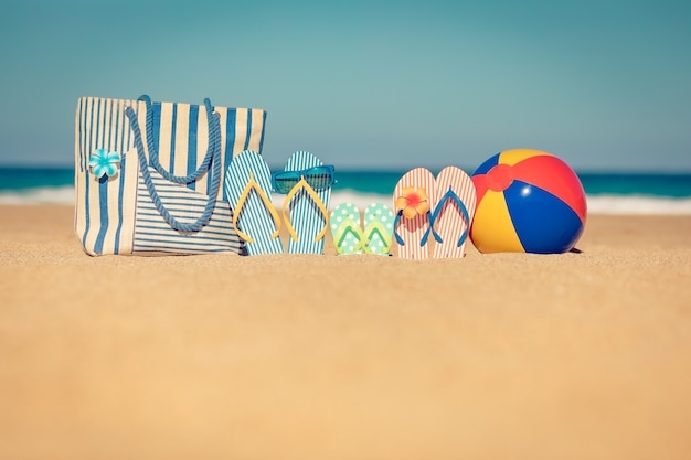 Пляжные шлепанцы на песке Концепция летних каникул