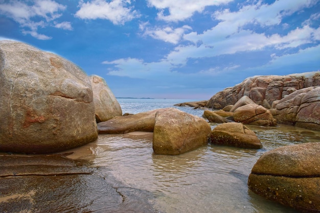 На пляже есть скалы и морская вода, красивая природа