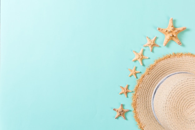 Beach hat with seashells on brown blue table. summer background concept with copy space top view.