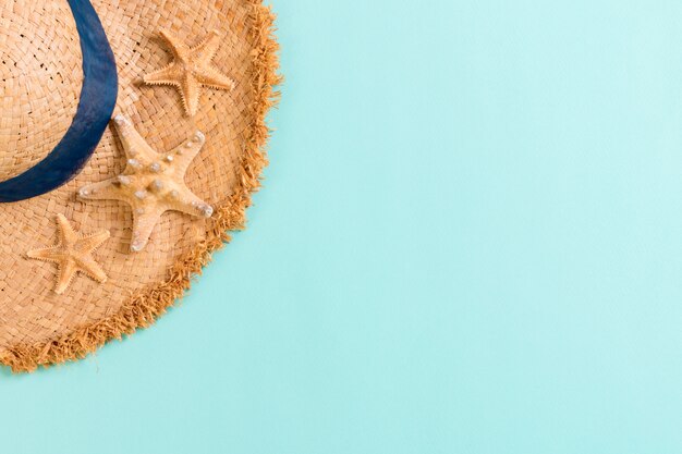 Beach hat with seashells on brown blue table. summer background concept with copy space top view