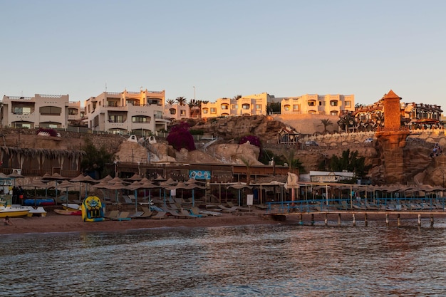 Beach and a hotel on the rocks at Sharks Bay in the evening. Sharm El Sheikh, South Sinai, Egypt