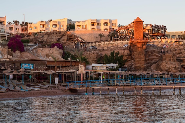 Photo beach and a hotel on the rocks at sharks bay in the evening. sharm el sheikh, south sinai, egypt