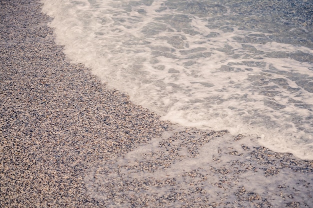 The beach of the Mediterranean coast with waves of azure water Summer sea breeze Selective focus