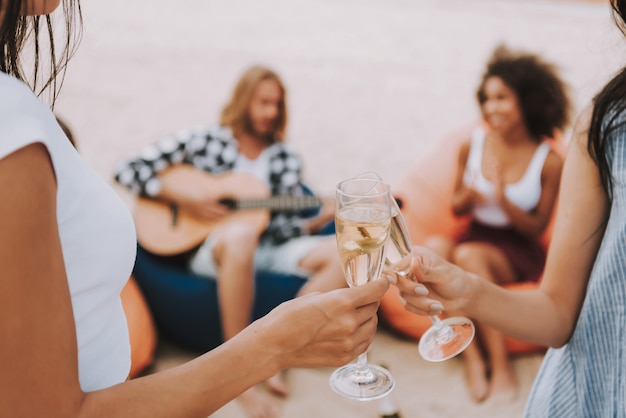 Beach party-gitaar spelen met champagne drinken.