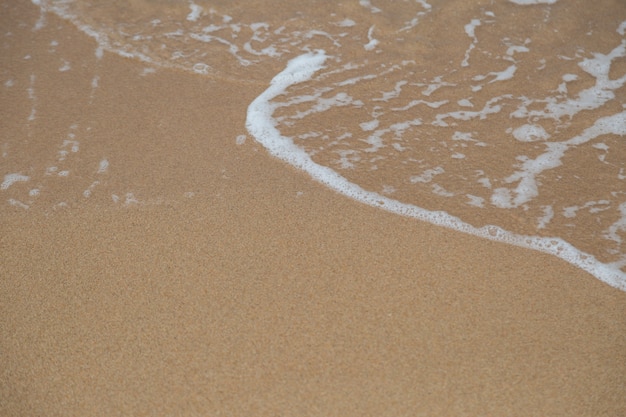 Spiaggia di sabbia e le onde del mare sullo sfondo