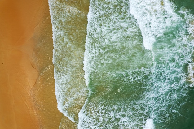 Beach Sand Sea Shore and waves white foamy summer sunny day backgroundAmazing beach top down view overhead seaside nature background