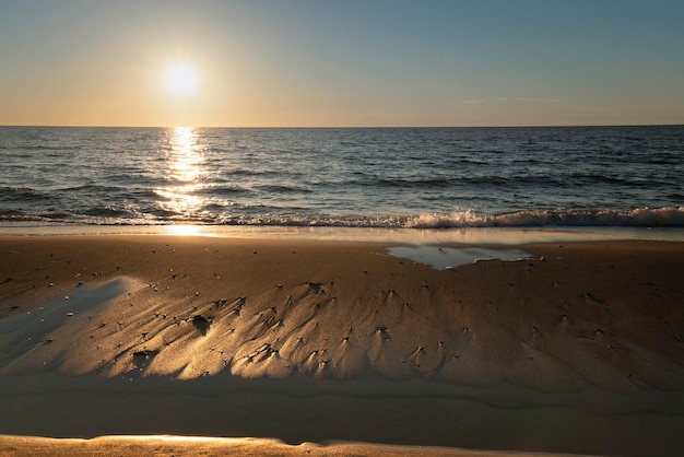 Песчаный пляж с галькой на берегу Балтийского моря на закате Куршская коса Калининградская область Россия