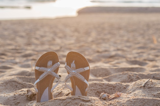 Photo on the beach sandy slippers stick up