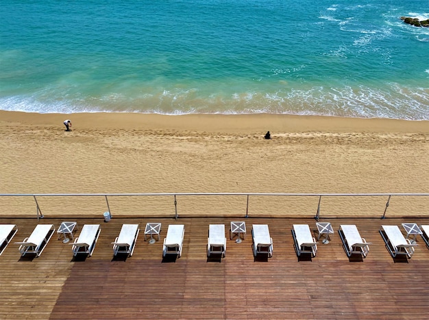 Photo a beach scene with lounge chairs and a beach view