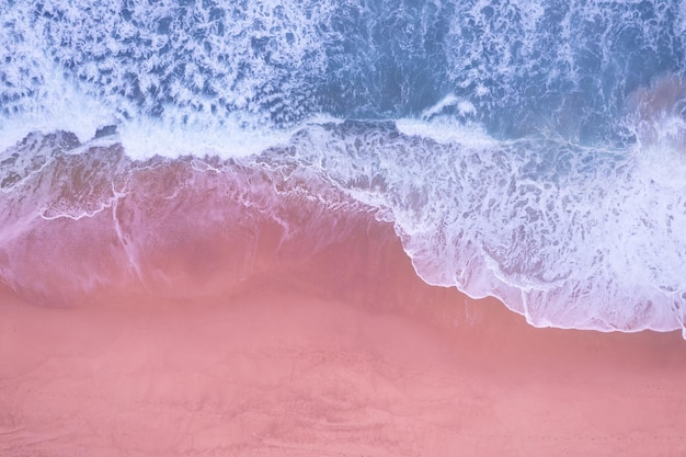 Beach sea surface aerial viewtop view blue water ocean waves\
with white foaming waves crashing on beach background amazing sea\
waves nature background