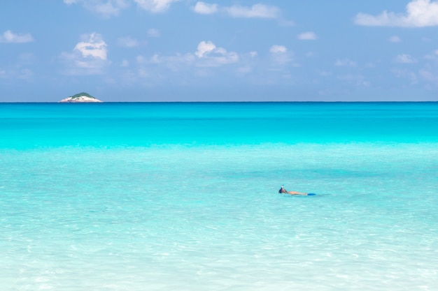 The beach of the Seychelles with blue water and stones