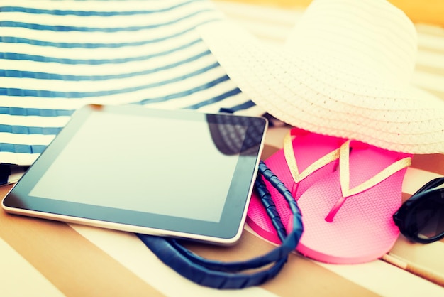 해변, 여름, 휴가, 액세서리 및 기술 개념 - 해변에서 태블릿 PC 컴퓨터 및 여름 액세서리 클로즈업