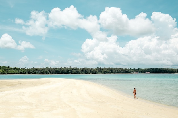 Beach travel - woman walking on sandy beach