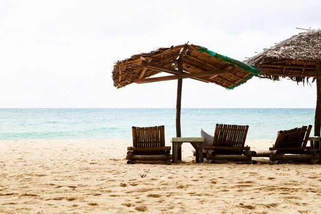 Beach umbrellas and loungers on the sandy seashore. Cloudy day