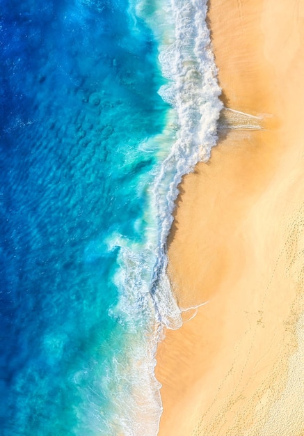 Foto spiaggia e onde come sfondo dalla vista dall'alto sfondo blu dell'acqua dal drone