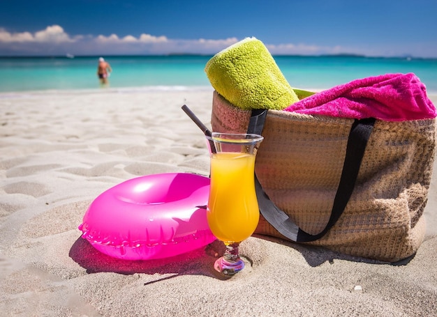 A beach with a basket and a drink on it