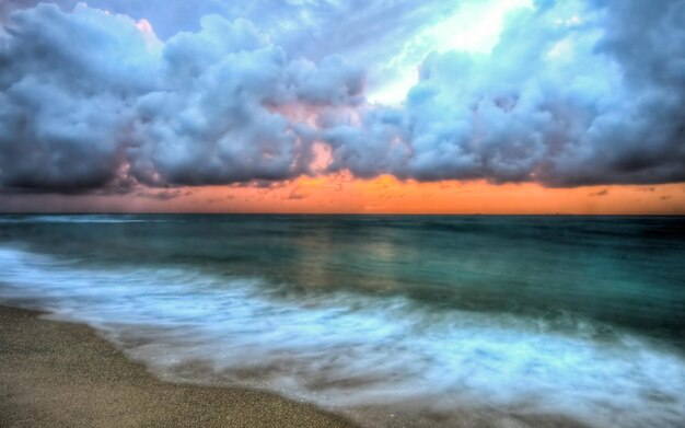 a beach with a beach and clouds in the sky